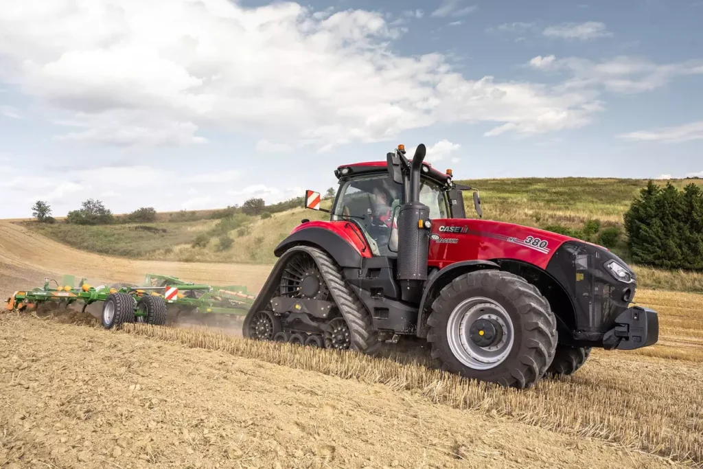 Case IH Magnum 380 Rowtrac-traktor med belter bak og hjul foran, som arbeider i en åker med et jordbearbeidingsredskap.