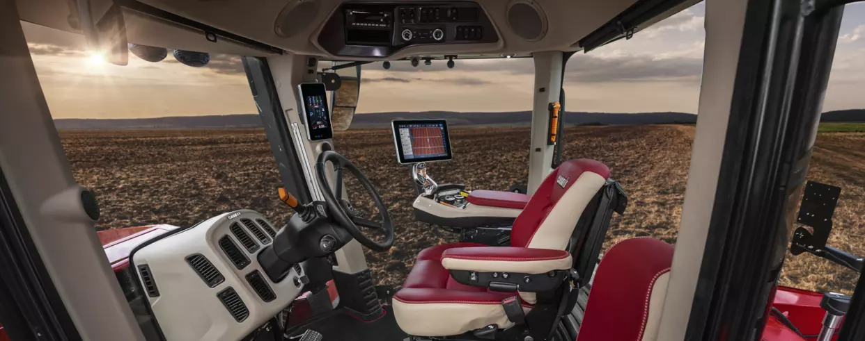 Moderne førerhus i Case IH Quadtrac-serien – Ergonomisk kabin med avansert teknologi og røde skinnseter.