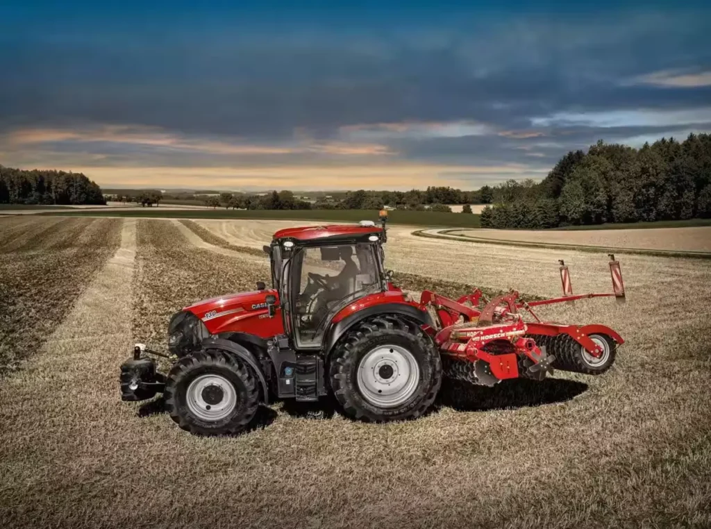 Rød Case IH Vestrum traktor med jordbruksredskap på en åker.