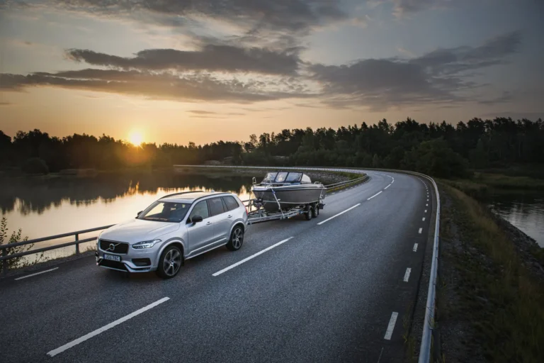 Brenderup båthenger som blir dratt av en hvit Volvo på landeveien