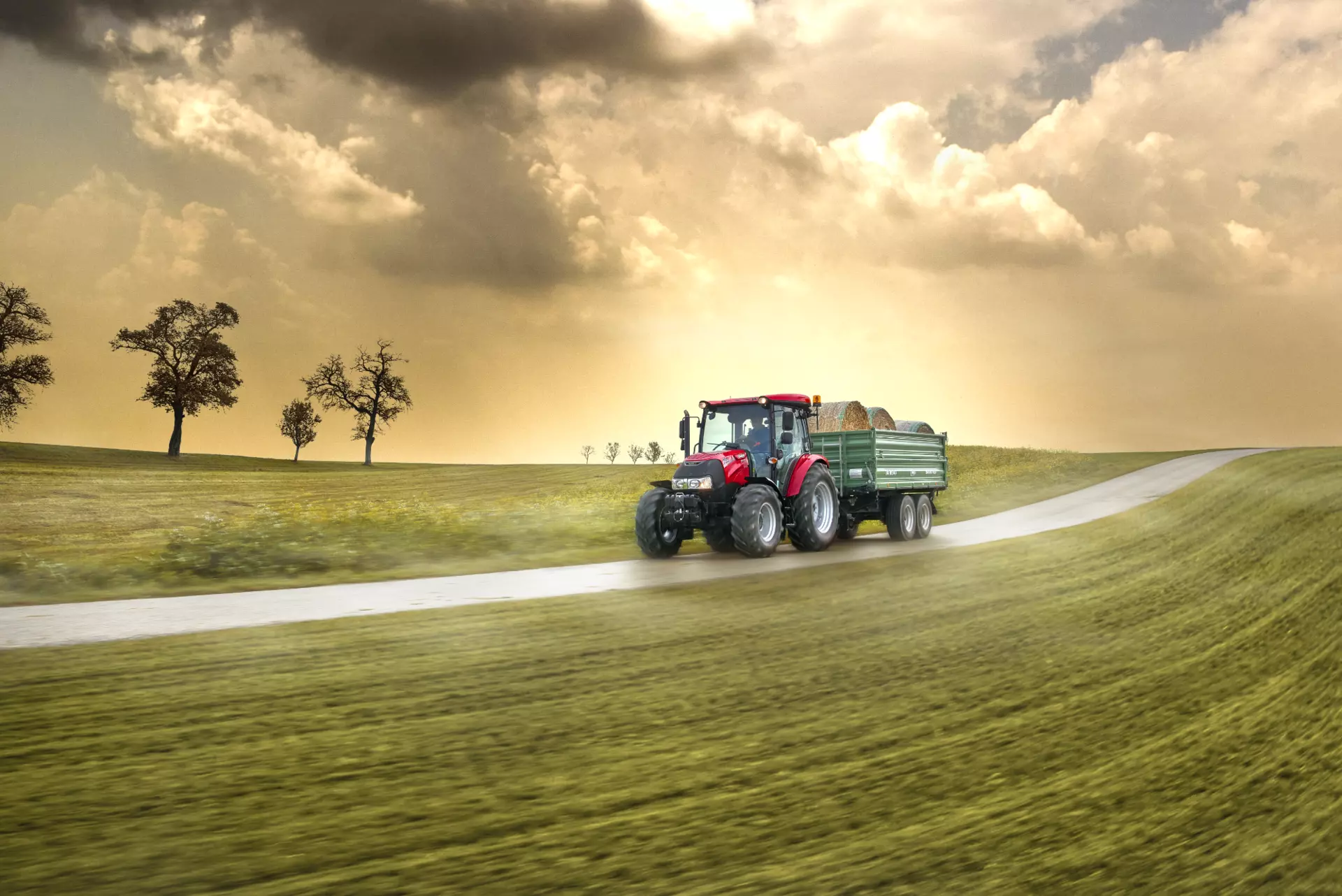 Farmall 55 kjører på landevei med en henger på slep