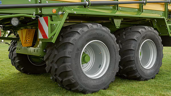Nærbilde av bakpartiet på grønn landbruksmaskin som viser doble store radialreifen med hvite felger montert på akselen.