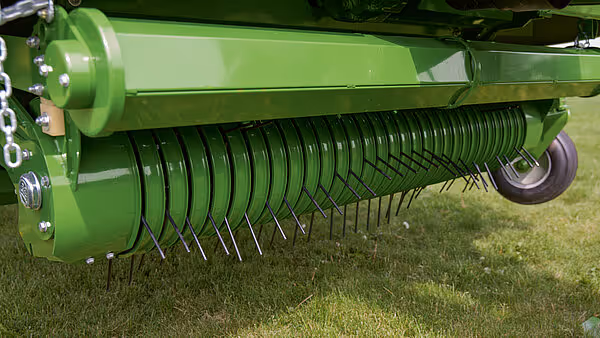 Nærbilde av oppsamlings- og sorteringsmekanisme med parallelle tinder på Krone-kartoffelskuff i grønt.