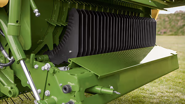 Nærbilde av rotorballen på KRONE AX med vertikalt monterte metallplater og hydraulisk sylinder.