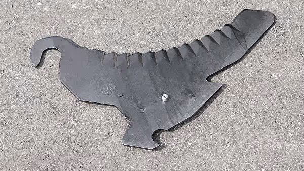 Metallisk kniv eller tine fra rotorballen på KRONE AX vist separat på betong.