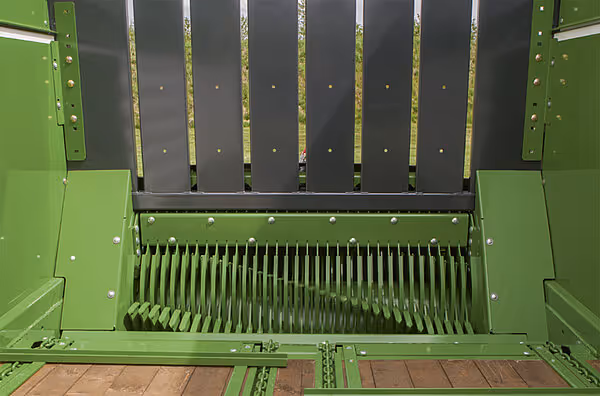 Pressemekanisme på KRONE AX-vogn med stålplate og kamfinger for komprimering av halm.