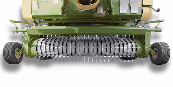 Nærbilde av oppsamlingssystemet på en Krone Bellima rundballpresse med metalliske tænder og grønne hjul.