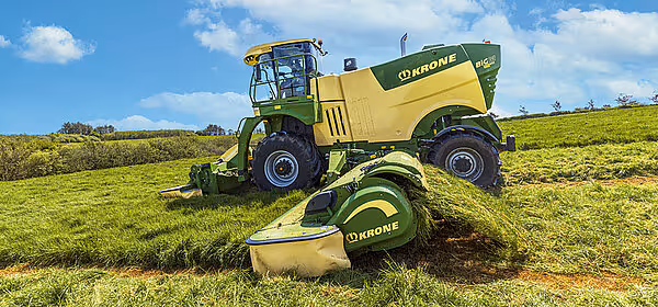 KRONE Big M 450 selvgående slåmaskin på slåttearbeid i kupert terreng med frontmontert slåtteredskap.
