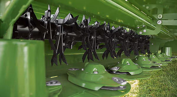 Slåmekanisme med skarpe kniver på KRONE Big M 450 slåmaskin. De sorte knivene er montert på en roterende trommel for gressklipping.