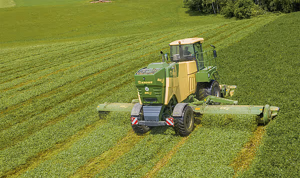 Dronebilde av KRONE Big M 450 slåmaskin som utfører slåttearbeid på eng med bred arbeidsbredde.