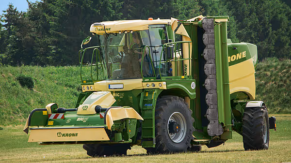 KRONE Big M 450 selvgående slåmaskin med stor førerhytte og høye hjul, fotografert på stubbeåker.
