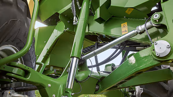 Detaljbilde av hydrauliske sylindrene og mekaniske deler på understellet til KRONE landbruksmaskinen.