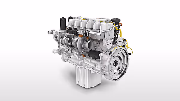 Motor til Krone Big M 450 slåmaskin, en moderne dieselmotor med sølvfarget finish. Motoren er fotografert mot hvit bakgrunn og viser tekniske detaljer.