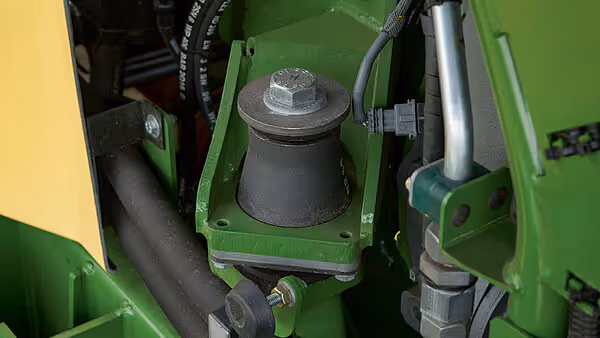 Nærbilde av hydraulisk komponent på Krone Big M 450, viser hydraulikkpumpe montert på grønt maskinramme. Hydraulikkslanger og rørledninger er synlige rundt komponenten.