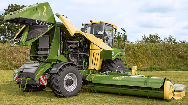 KRONE Big M 450 selvgående slåmaskin i grønt og gult på gressmark, med stor frontmontert slåtteenhet.