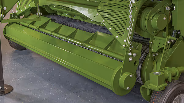 Opptaksrull og transportbånd på KRONE storballpresse med grønne deksler og metallkomponenter.