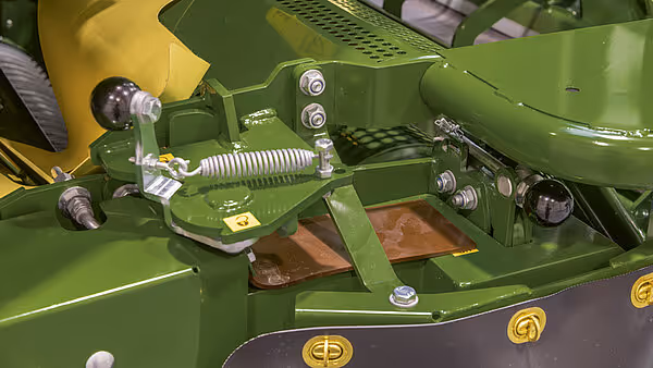 Grønn KRONE BigPack landbruksmaskin med detaljert visning av mekaniske komponenter og hydrauliske systemer. Maskinen har karakteristisk grønn og gul fargeskjema.