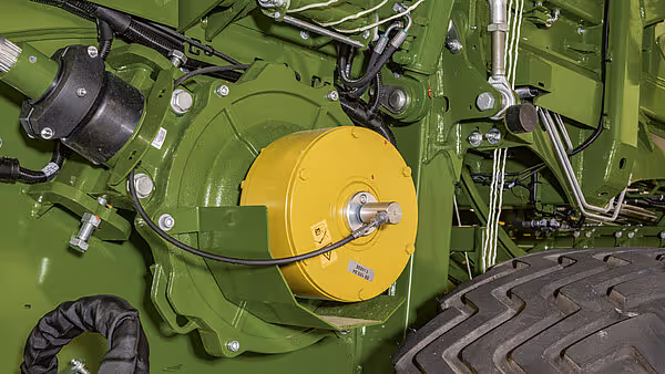 Gul oppviklingstrommel og drivmekanisme på KRONE BigPack ballpresse. Grønt chassis med hydraulikk og kraftoverføring synlig.