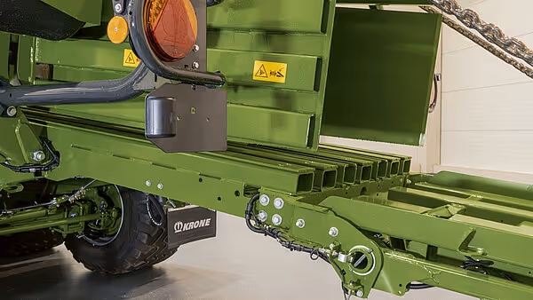 Bakre del av grønn landbruksmaskin med trekkinnretning og hydrauliske tilkoblinger. KRONE-logoen er synlig på utstyret.