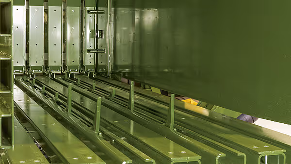 Innvendig mekanisme i rundballer som viser metallstrukturer og pressekomponenter. Grønne komponenter dominerer det indre systemet.