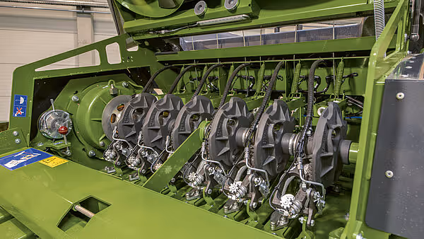 Detaljert bilde av pressemekanismen med roterende elementer og metallkomponenter. Flere hydrauliske sylindre og drivverk er synlige.