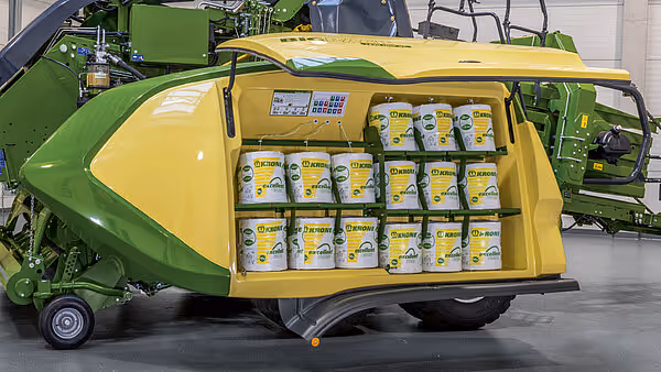 KRONE Big Pack Gen 5 rundballpresse med åpent servicerom som viser oppbevaring av reservedeler og vedlikeholdsutstyr i gule bokser.