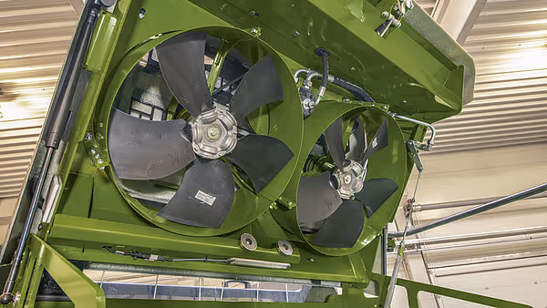 To store vifter montert inne i KRONE BigPack pressemaskin for luftsirkulasjon under pressing. Viftene er montert i grønt metallchassis med kraftige motorer.