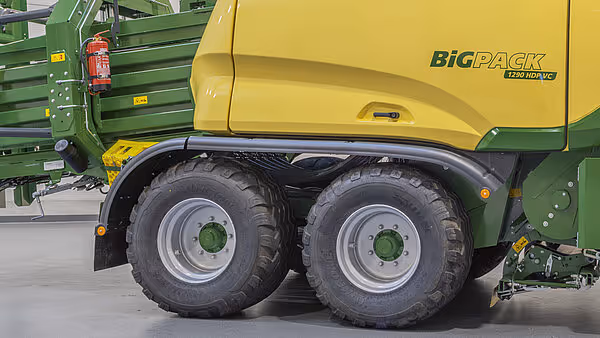 Dobbelt hjulsett på en gul og grønn Krone BigPack rundballpress med store landbrukshjul og grønne felger.
