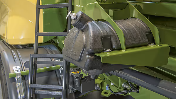 Detaljbilde av hydraulisk sylinder og roterende komponenter på KRONE Big Pack ballepresse. Deler av maskinens grønne ramme og mekaniske systemer er synlige.