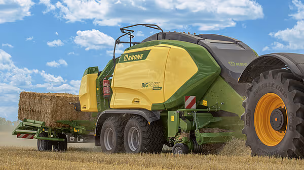 KRONE Big Pack Gen 5 storballpresse med åpent bakdeksel som viser ballekammeret. Maskinen står på stubbeåker med store baller synlige i bakgrunnen.