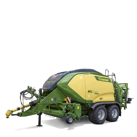En Krone BigPack rundballpresse i grønn og gul farge på hvit bakgrunn. Maskinen har store hjul og er designet for å lage rundballer av høy og halm.