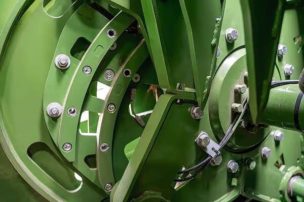 Nærbilde av grønne mekaniske komponenter på KRONE BigPack HDP II ballepresse, med synlige bolter og bevegelige deler.