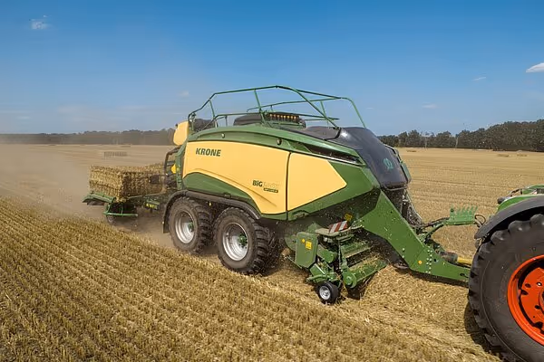 KRONE Big Pack HDP II storballpresse i drift på åker, produserer firkantballer av halm.