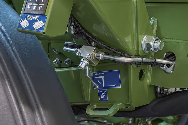 Hydraulisk tilkobling og kontrollpanel på grønn Krone BigPack HDP II rundballpresse. Hydraulikkslanger og betjeningselementer er synlige på maskinsiden.