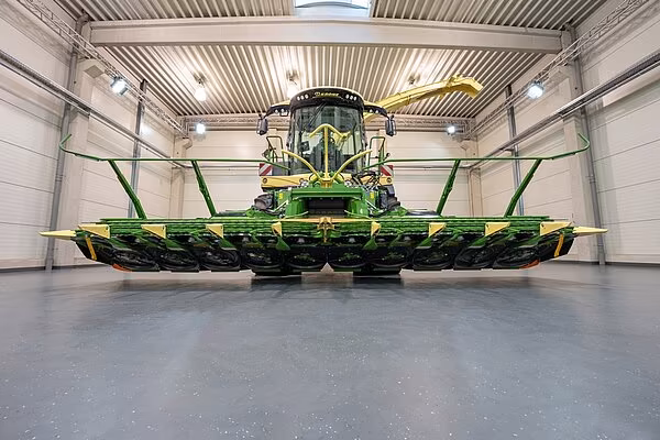 KRONE BiG X felthøster med XCollect RotoChop maishøstehode sett forfra innendørs, med mulchingenheter i arbeidsposisjon.