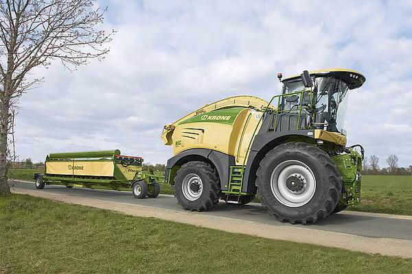 KRONE BiG X felthøster på landevei med XDisc direktekutterskjærebord på tilhengervogn med integrert bremse.