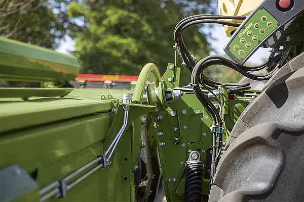 Nærbilde av koblingsmekanisme og hydraulikkslanger ved montering av KRONE XDisc skjærebord på felthøster.