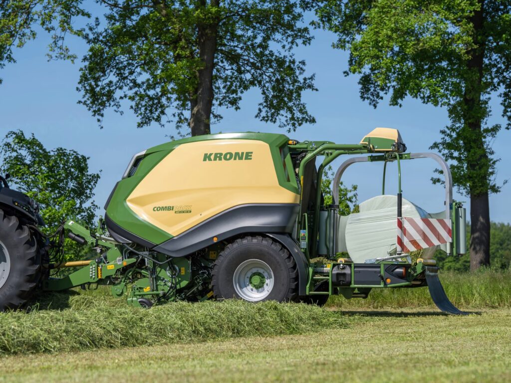 Nærbilde av pickup og innmatingsmekanismen på KRONE CombiPack HDP CV 165 XC i arbeid på eng.