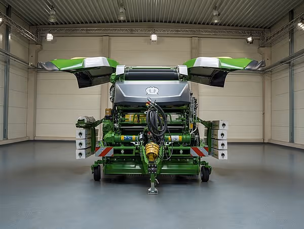 KRONE Combipack-HDP rundballpresse i verkstedhall med åpnet pressekammer som viser det grønne interiøret.