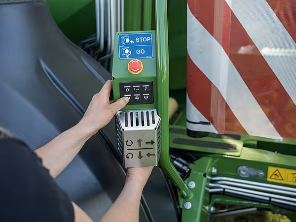 Nærbilde av kontrollpanel på KRONE ballepresse med stopp/start-knapper og betjeningsbryter.