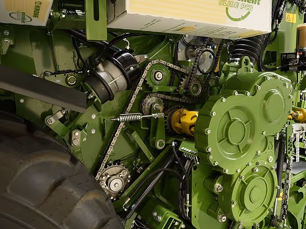 Detaljbilde av drivverk og kraftoverføring med kjeder og tannhjul på grønn KRONE maskin.