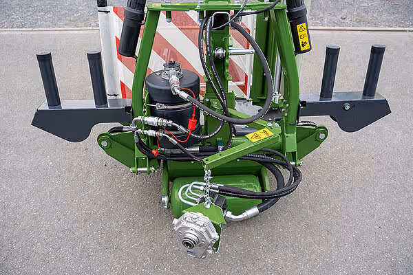 KRONE EasyWrap 150 ballpresse med grønne hydrauliske komponenter og svarte skjær montert på maskinens underside.