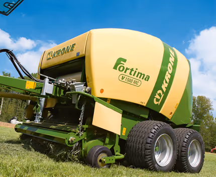 Krone Fortima rundballpresse sett fra siden, viser maskinens gul-grønne fargekombinasjon og kompakte design.