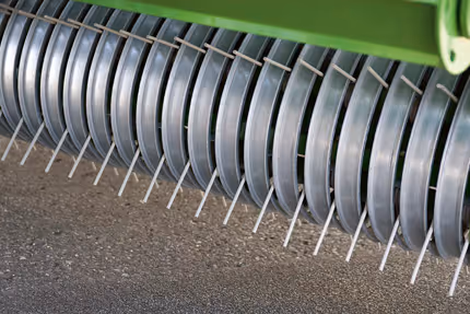 Rækken av buede tinder på KRONE Fortima som samler og transporterer høy eller gras inn i maskinen.