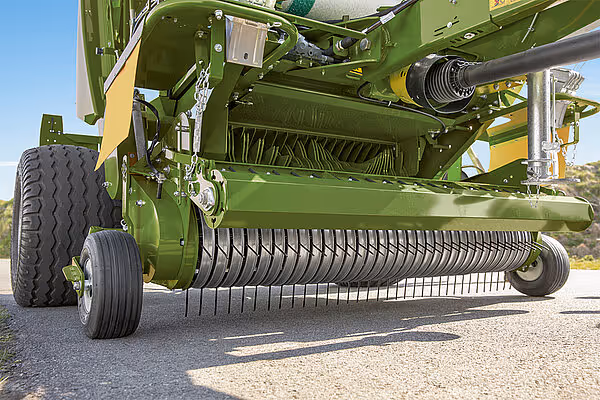 Nærbilde av pickup-enheten på KRONE Fortima rundballpresse med fjærbelastede tinner.