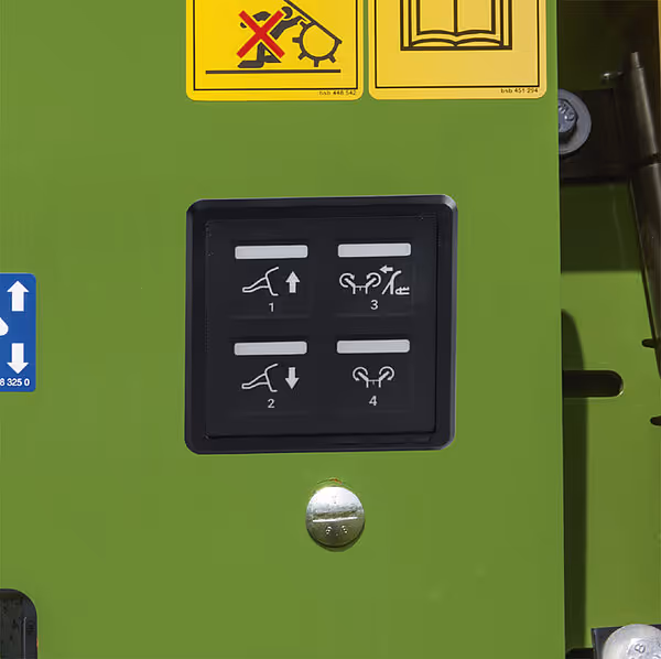 Kontrollpanel på KRONE MX med fire nummererte funksjonsknapper som styrer ulike hydrauliske operasjoner av pressevalsene.