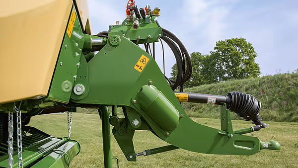 Hydraulisk styringssylinder og mekanismer på siden av KRONE MX pressemaskinen under feltarbeid.