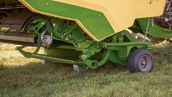 Underside av KRONE MX pressemaskin som viser hydraulisk sylinder, mekanikk og transporthjul.