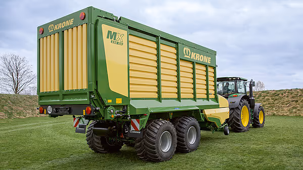 KRONE MX silofôrvogn fotografert fra siden på grønt område med traktorkupler.