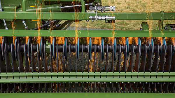 Rotorkammer med slipeskiver i drift fylt med halm og organisk materiale fra fôrspredningen.